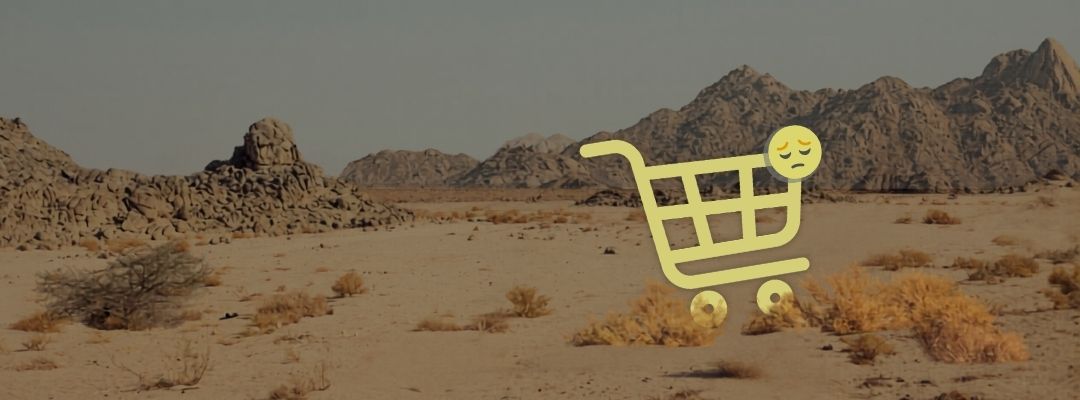 a cart icon with a sad face sits alone in a desert