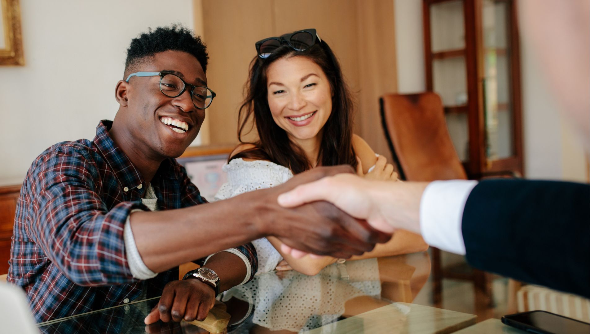 a happy couple closing a deal with a handshake